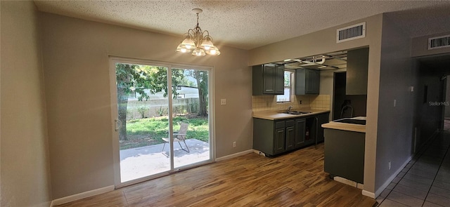 2503 Elm St, Seffner, FL 33584 - kitchen featuring light countertops, a chandelier, backsplash, a sink, and wood finished floors