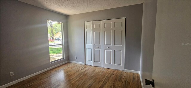 2503 Elm St, Seffner, FL 33584 - unfurnished bedroom with wood finished floors, a textured ceiling, baseboards, and a closet