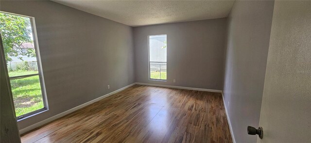 2503 Elm St, Seffner, FL 33584 - empty room with wood finished floors, baseboards, and a textured ceiling