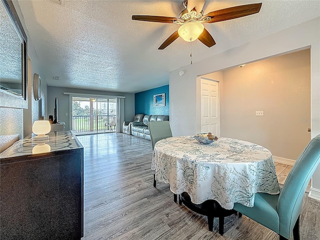 200 Country Club Dr Unit 202, Largo, FL 33771 - dining area featuring a textured ceiling, wood finished floors, a ceiling fan, and baseboards