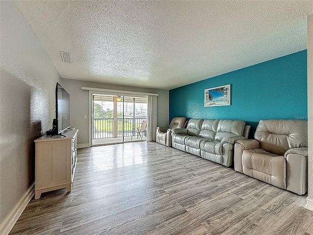 200 Country Club Dr Unit 202, Largo, FL 33771 - living area with a textured ceiling, wood finished floors, and baseboards