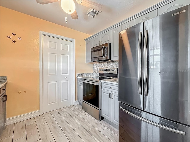 200 Country Club Dr Unit 202, Largo, FL 33771 - kitchen featuring stainless steel appliances, ceiling fan, tasteful backsplash, and baseboards