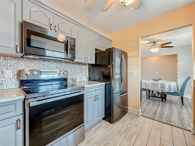 200 Country Club Dr Unit 202, Largo, FL 33771 - kitchen featuring appliances with stainless steel finishes, ceiling fan, light wood-type flooring, and decorative backsplash