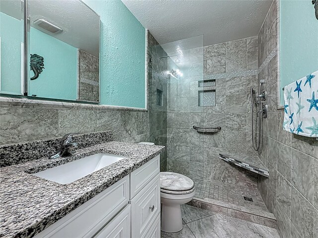200 Country Club Dr Unit 202, Largo, FL 33771 - bathroom with tile walls, toilet, vanity, a walk in shower, and a textured ceiling