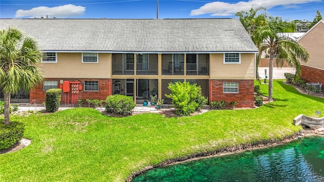 200 Country Club Dr Unit 202, Largo, FL 33771 - rear view of property with brick siding, a lawn, and a shingled roof