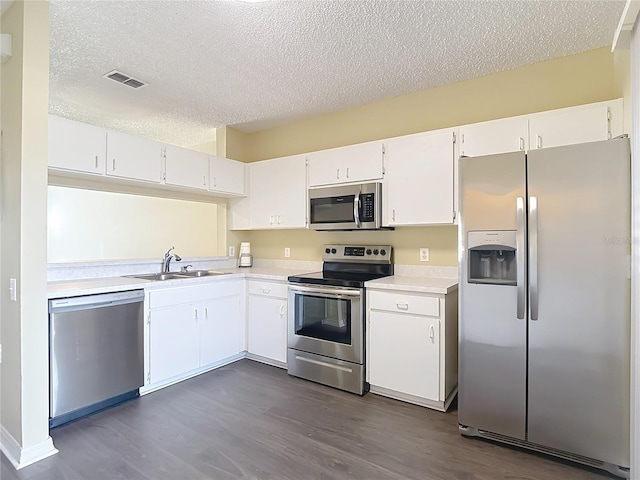 12464 Berkeley Square Dr, Tampa, FL 33626 - kitchen with stainless steel appliances, a textured ceiling, light countertops, dark wood-type flooring, and white cabinetry