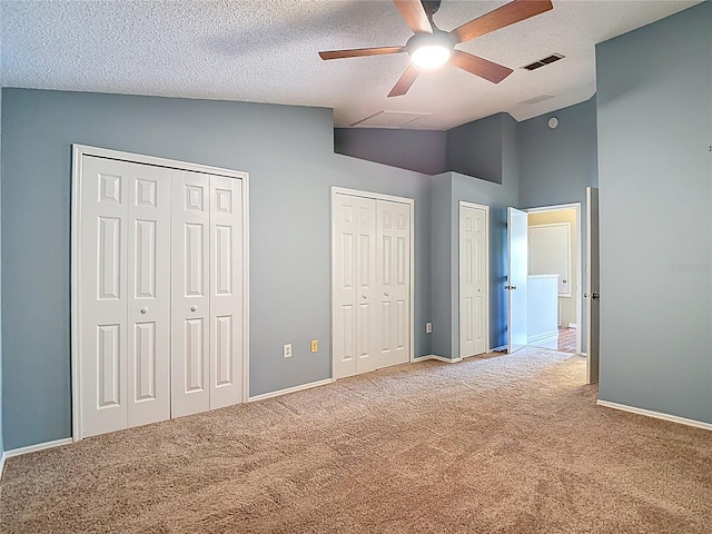 12464 Berkeley Square Dr, Tampa, FL 33626 - unfurnished bedroom featuring carpet, two closets, a textured ceiling, high vaulted ceiling, and ceiling fan