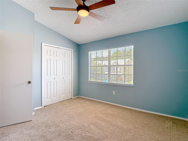 12464 Berkeley Square Dr, Tampa, FL 33626 - unfurnished bedroom featuring carpet floors, a textured ceiling, a closet, lofted ceiling, and ceiling fan