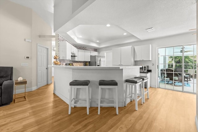 6051 65th Ave N, Pinellas Park, FL 33781 - kitchen with appliances with stainless steel finishes, light wood-type flooring, a breakfast bar, a peninsula, and recessed lighting