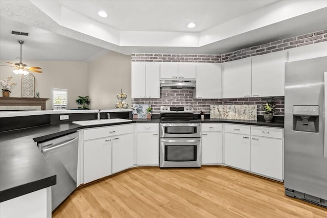 6051 65th Ave N, Pinellas Park, FL 33781 - kitchen featuring appliances with stainless steel finishes, under cabinet range hood, light wood-type flooring, dark countertops, and recessed lighting