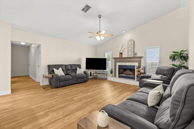 6051 65th Ave N, Pinellas Park, FL 33781 - living area featuring a ceiling fan, vaulted ceiling, light wood-style flooring, and a tile fireplace