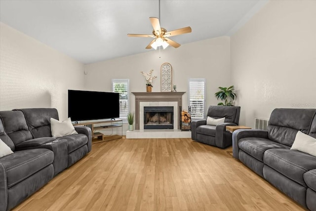 6051 65th Ave N, Pinellas Park, FL 33781 - living room with light wood-style flooring, vaulted ceiling, ceiling fan, and a tile fireplace