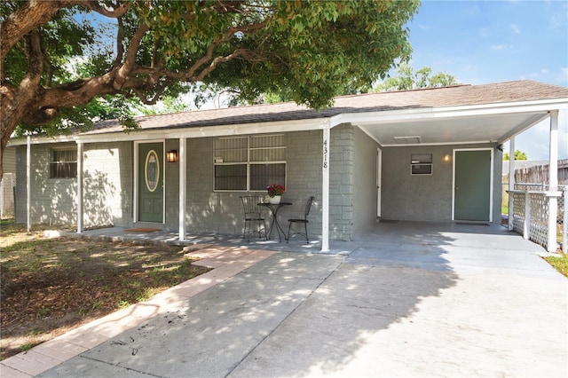 4318 Mesa Dr, New Port Richey, FL 34653 - ranch-style house with concrete driveway, covered porch, an attached carport, and roof with shingles
