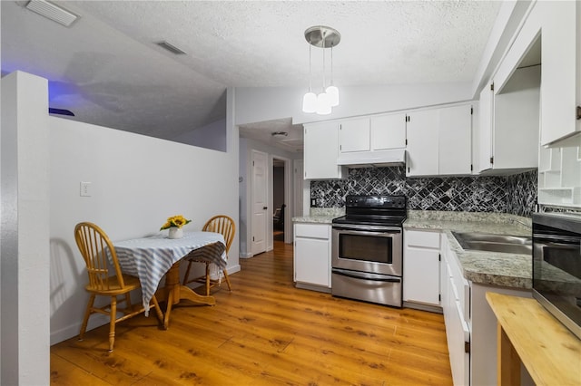 4318 Mesa Dr, New Port Richey, FL 34653 - kitchen featuring electric range, vaulted ceiling, under cabinet range hood, tasteful backsplash, and a textured ceiling