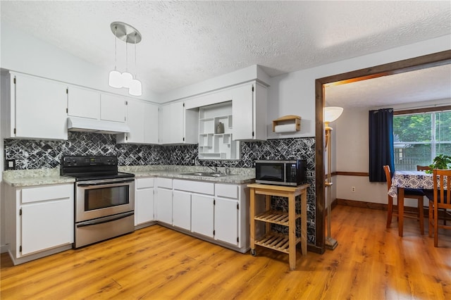 4318 Mesa Dr, New Port Richey, FL 34653 - kitchen featuring stainless steel appliances, under cabinet range hood, light wood finished floors, light countertops, and a textured ceiling