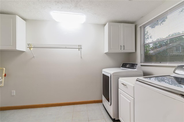 4318 Mesa Dr, New Port Richey, FL 34653 - laundry room featuring cabinet space, washing machine and dryer, a textured ceiling, and light tile patterned floors