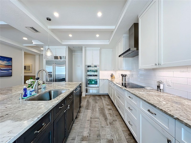1204 Derby Ln, Sarasota, FL 34242 - kitchen with appliances with stainless steel finishes, wall chimney exhaust hood, a sink, white cabinets, and wood finished floors