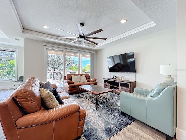 1204 Derby Ln, Sarasota, FL 34242 - living area featuring a tray ceiling, wood finished floors, plenty of natural light, ceiling fan, and a textured ceiling