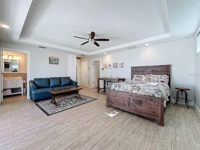 1204 Derby Ln, Sarasota, FL 34242 - bedroom featuring a raised ceiling, a textured ceiling, wood finish floors, ceiling fan, and connected bathroom