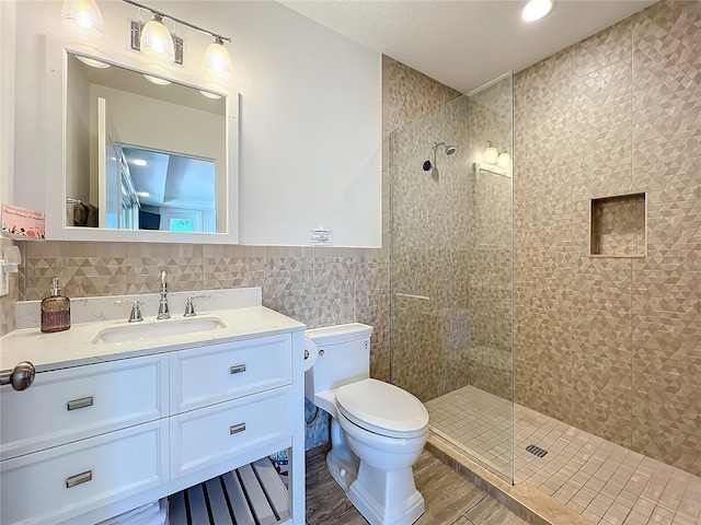 1204 Derby Ln, Sarasota, FL 34242 - full bath with toilet, tile walls, vanity, tiled shower, and a wainscoted wall