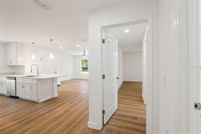 10219 Huntley St, New Port Richey, FL 34654 - kitchen featuring light wood-type flooring, white cabinetry, open floor plan, dishwasher, and light countertops