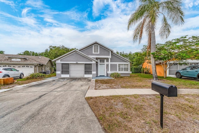 921 Linn Harbor Ct, Tarpon Springs, FL 34689 - view of front of property with stucco siding, a garage, concrete driveway, and a front lawn