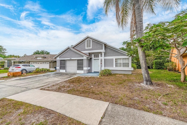 921 Linn Harbor Ct, Tarpon Springs, FL 34689 - view of front facade with stucco siding, driveway, an attached garage, and a front lawn