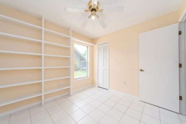 921 Linn Harbor Ct, Tarpon Springs, FL 34689 - spare room with a ceiling fan, baseboards, light tile patterned floors, and built in shelves