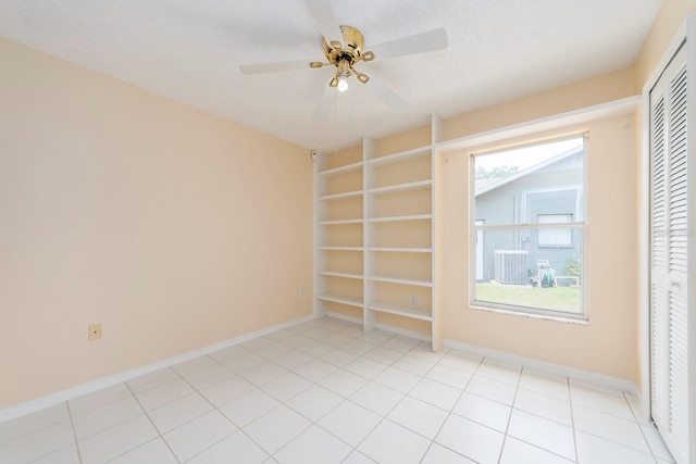 921 Linn Harbor Ct, Tarpon Springs, FL 34689 - spare room featuring built in shelves, ceiling fan, baseboards, a textured ceiling, and light tile patterned floors