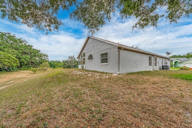 921 Linn Harbor Ct, Tarpon Springs, FL 34689 - view of home's exterior featuring stucco siding, a lawn, and central air condition unit