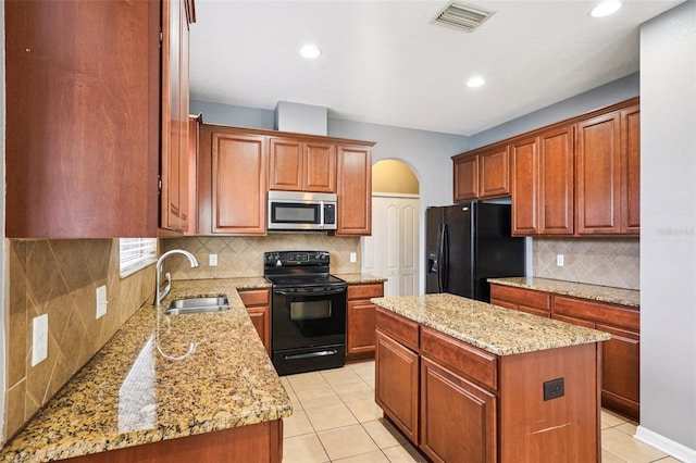 7509 Tangle Bend Dr, Gibsonton, FL 33534 - kitchen featuring black appliances, arched walkways, a center island, tasteful backsplash, and light stone countertops