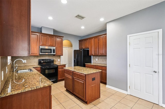 7509 Tangle Bend Dr, Gibsonton, FL 33534 - kitchen with black appliances, arched walkways, backsplash, a center island, and light stone counters