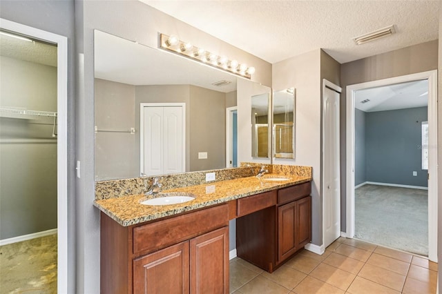 7509 Tangle Bend Dr, Gibsonton, FL 33534 - full bath with double vanity, tile patterned floors, a textured ceiling, and a spacious closet