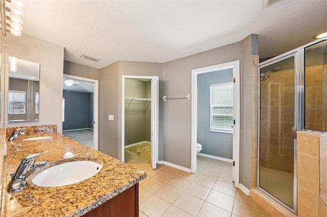 7509 Tangle Bend Dr, Gibsonton, FL 33534 - full bathroom with a shower stall, plenty of natural light, double vanity, a spacious closet, and a textured ceiling
