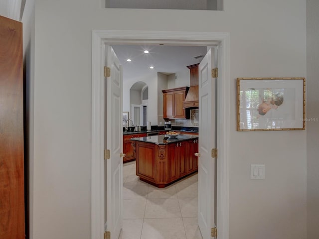 4335 Clairidge Way, Palm Harbor, FL 34685 - kitchen with dark countertops, backsplash, custom range hood, light tile patterned floors, and a kitchen island