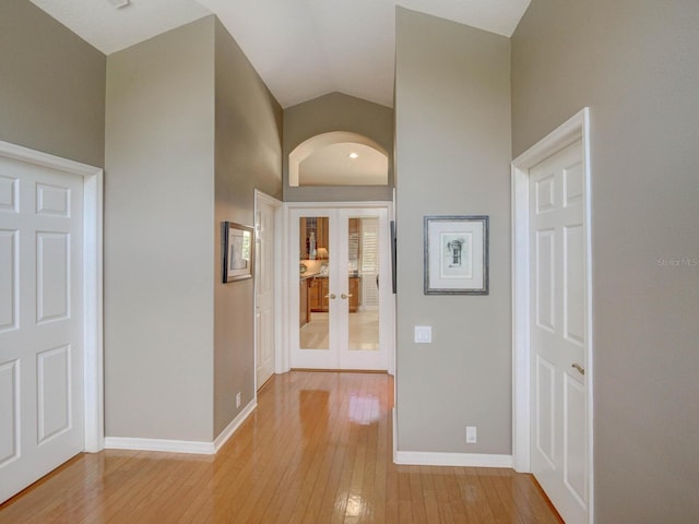 4335 Clairidge Way, Palm Harbor, FL 34685 - hallway featuring french doors, light wood-style floors, and vaulted ceiling