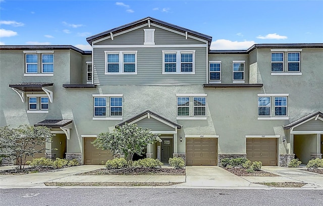 4567 Tuscan Loon Dr, Tampa, FL 33619 - view of property featuring a garage, stucco siding, and driveway