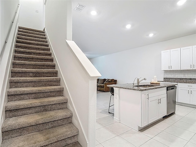 4567 Tuscan Loon Dr, Tampa, FL 33619 - kitchen featuring dishwasher, tasteful backsplash, white cabinetry, a breakfast bar area, and dark stone countertops