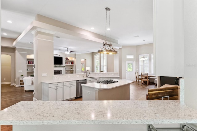 5823 Terncrest Dr, Lithia, FL 33547 - kitchen with appliances with stainless steel finishes, ceiling fan, arched walkways, a kitchen island, and a peninsula