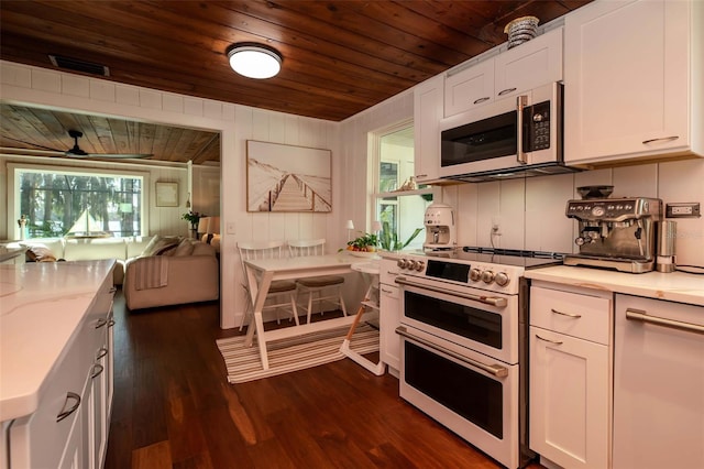 19209 Crooked Ln, Lutz, FL 33548 - kitchen featuring double oven range, stainless steel microwave, wooden ceiling, white cabinetry, and dark wood-style flooring