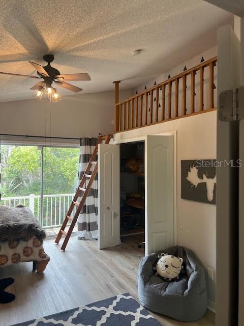 1050 Starkey Rd Unit 106, Largo, FL 33771 - bedroom with access to outside, a textured ceiling, light wood-style floors, and a ceiling fan