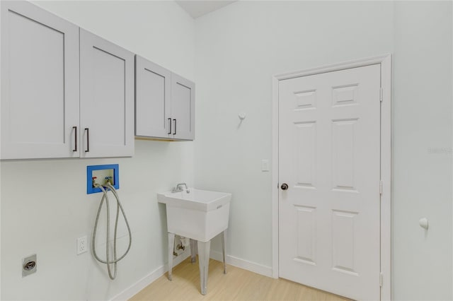 1729 Arabian Ln, Palm Harbor, FL 34685 - washroom featuring cabinet space, washer hookup, light wood-type flooring, and electric dryer hookup