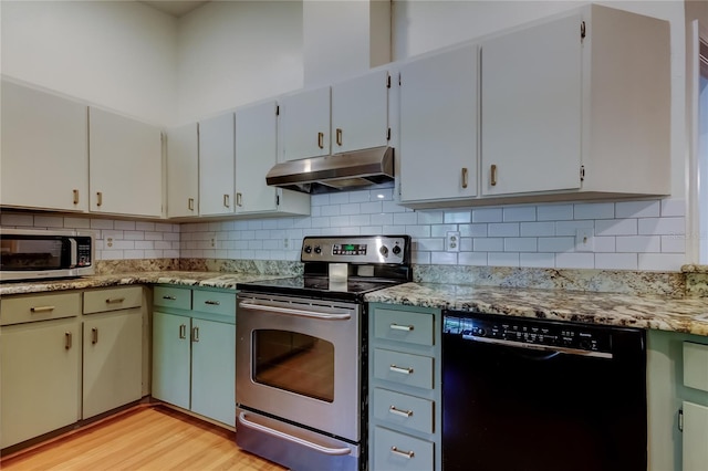 17631 Grove View Dr, Lutz, FL 33549 - kitchen featuring appliances with stainless steel finishes, under cabinet range hood, light wood-type flooring, and backsplash