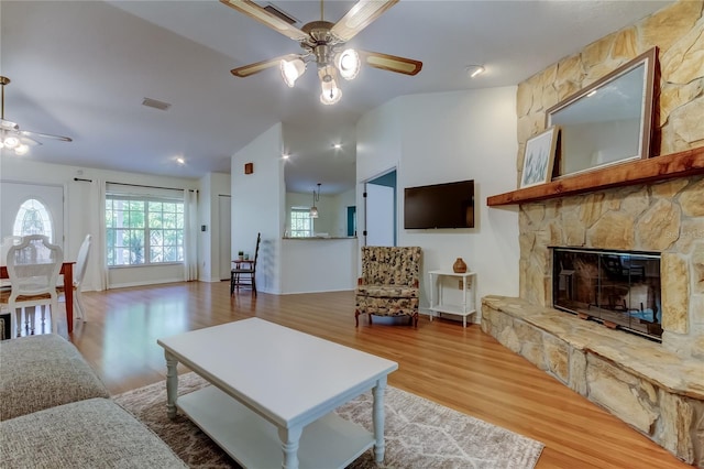 17631 Grove View Dr, Lutz, FL 33549 - living room featuring ceiling fan, wood finished floors, lofted ceiling, and a stone fireplace