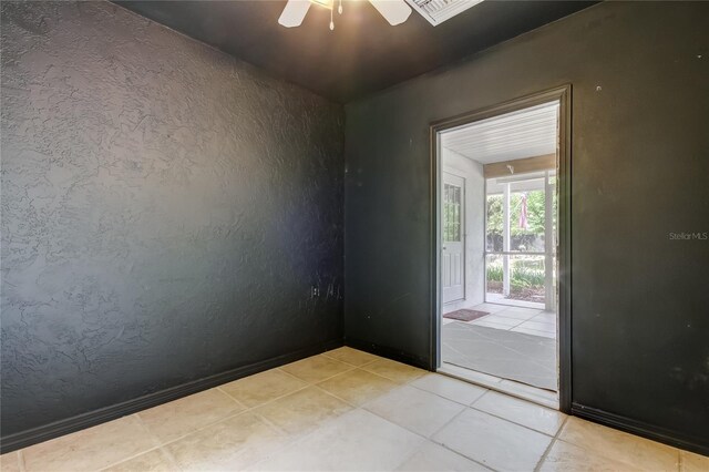 17631 Grove View Dr, Lutz, FL 33549 - empty room featuring ceiling fan, light tile patterned floors, and a textured wall