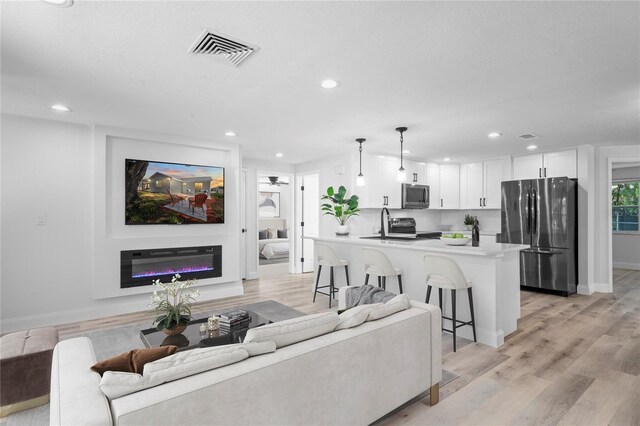 6442 Sutherland Ave, New Port Richey, FL 34653 - living area featuring recessed lighting, light wood-style flooring, and a glass covered fireplace