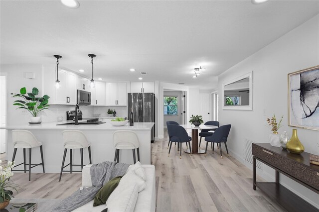 6442 Sutherland Ave, New Port Richey, FL 34653 - kitchen with a peninsula, appliances with stainless steel finishes, light countertops, a breakfast bar area, and recessed lighting