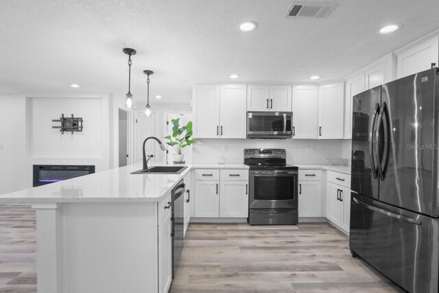 6442 Sutherland Ave, New Port Richey, FL 34653 - kitchen with stainless steel appliances, a peninsula, light wood finished floors, white cabinets, and recessed lighting