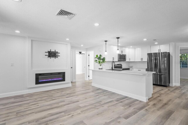 6442 Sutherland Ave, New Port Richey, FL 34653 - kitchen featuring stainless steel appliances, recessed lighting, white cabinetry, light countertops, and light wood-style floors