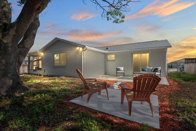 6442 Sutherland Ave, New Port Richey, FL 34653 - back of property at dusk featuring a patio area and stucco siding